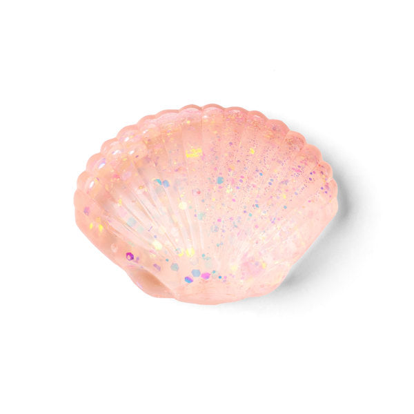 A pink resin seashell-shaped container filled with iridescent glitter, shown on a clean white background.