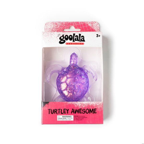 A purple glittery turtle-shaped product in retail packaging, with the brand name 'goolala' visible at the top and the text 'TURTLEY AWESOME' on the lower pink section of the box.