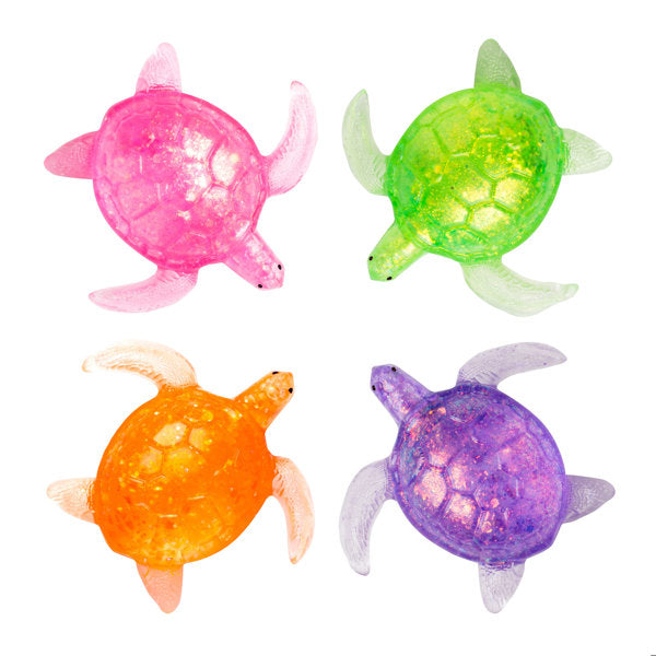 Four translucent turtle-shaped stress toys arranged in a 2x2 grid on a white background, featuring pink, green, orange, and purple shells with glittery textures.
