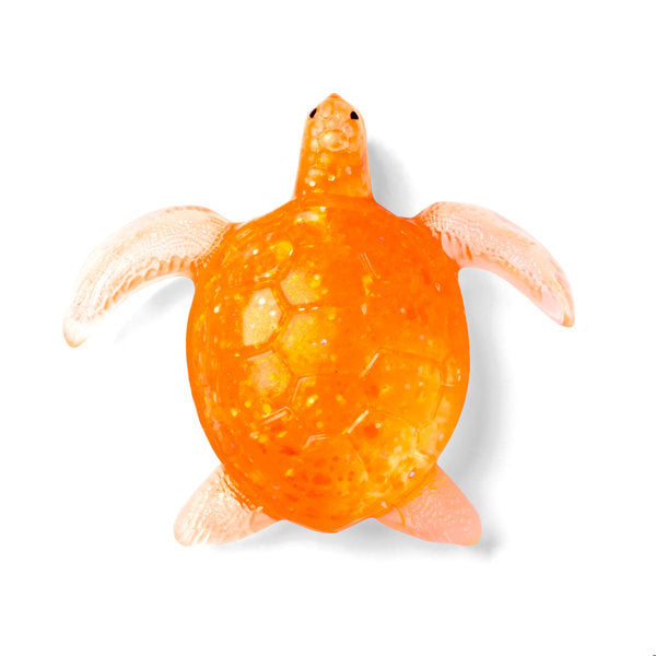 An orange translucent sea turtle toy with pale pinkish-beige flippers and legs, isolated on a white background.