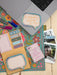 Notebook with decorative stickers and a laptop on a floral-patterned surface