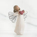 Angel figurine holding a heart on a white background