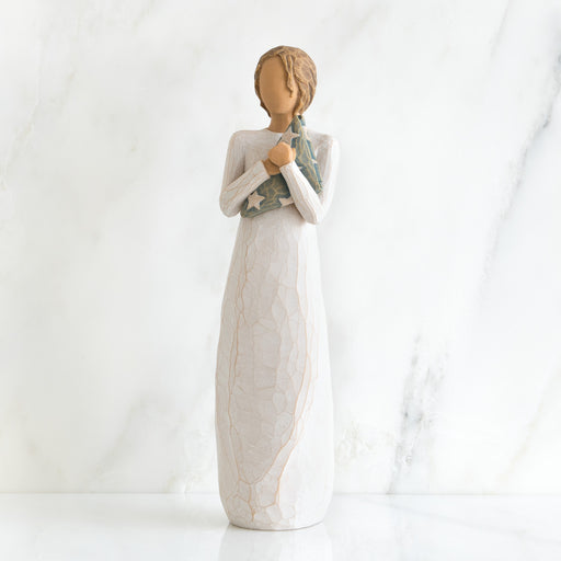 Decorative figurine of a woman holding a baby wrapped in a blanket on a white background