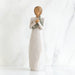 Decorative figurine of a woman holding a baby wrapped in a blanket on a white background