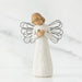 Angel figurine with wire wings on a marble surface