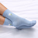 Light blue socks with daisy flower designs on a white background