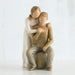 Wooden figurine of a woman embracing a child on a white background