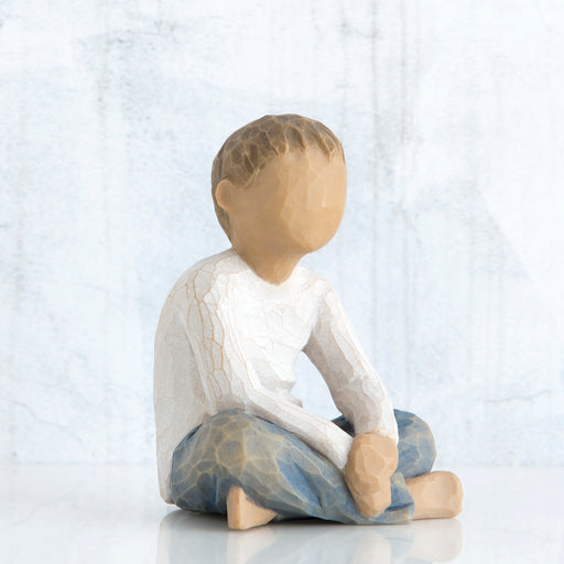 Statue of a child sitting on a white background
