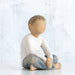 Statue of a child sitting on a white background