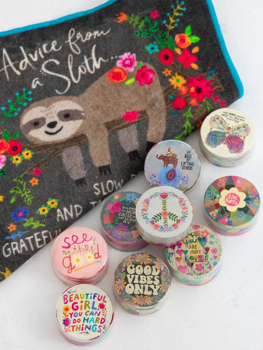 Decorative items with motivational phrases and a sloth design on a colorful background