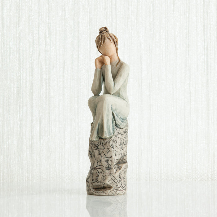 Statue of a woman sitting with her hands on her face against a white background