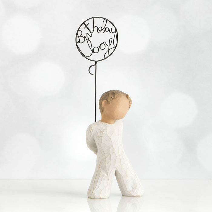 Decorative figure with a balloon-shaped sign reading 'Birthday Boy' on a white background